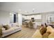 Open-concept living room and kitchen featuring wood floors, white cabinets, and stainless steel appliances at 8160 Nik St, Brownsburg, IN 46112
