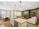 View of a modern open concept kitchen and living area with stainless steel appliances and wood plank accent wall at 8160 Nik St, Brownsburg, IN 46112