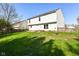 Expansive backyard featuring lush green grass, a small patio, and the home's white exterior at 8424 Nuckols Ln, Indianapolis, IN 46237