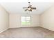 A bedroom featuring a ceiling fan, large window, and neutral tones at 8424 Nuckols Ln, Indianapolis, IN 46237
