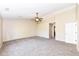 A large bedroom featuring a ceiling fan, neutral tones, and new carpet at 8424 Nuckols Ln, Indianapolis, IN 46237
