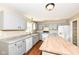 Spacious kitchen with gray cabinets, granite countertops, a wooden island, modern appliances, and hardwood floors at 8424 Nuckols Ln, Indianapolis, IN 46237