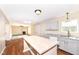 Open concept kitchen with gray cabinetry, a wooden island, and living room with fireplace in the background at 8424 Nuckols Ln, Indianapolis, IN 46237