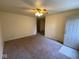 Cozy living room with neutral carpet, ceiling fan, and a bright front door, ready for personal touches at 914 Greenwood E Trl, Greenwood, IN 46142