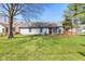 Backyard featuring well-kept lawn, mature trees, and a deck at 923 Jonathan Dr, Plainfield, IN 46168