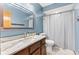 Bathroom featuring blue walls, marble vanity top, wood cabinets and shower with white curtain at 923 Jonathan Dr, Plainfield, IN 46168