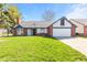 Charming single-story home featuring a well-manicured lawn, two-car garage, and brick accents at 923 Jonathan Dr, Plainfield, IN 46168