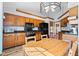 Eat-in kitchen with wood cabinets, black appliances and a chandelier at 923 Jonathan Dr, Plainfield, IN 46168