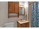 Functional bathroom featuring a vanity, medicine cabinet, toilet, and shower with a blue patterned curtain at 947 E Bradbury Ave, Indianapolis, IN 46203