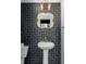 Stylish half bathroom featuring dark tiled wall, a gold mirror, and pedestal sink at 998 Kinzer Ave, Carmel, IN 46032
