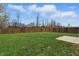Spacious backyard with grass, a privacy fence, and a small concrete patio at 10016 Jenna Ln, Indianapolis, IN 46239