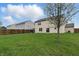 Spacious backyard with lush green grass, a wood fence, and a patio area at 10016 Jenna Ln, Indianapolis, IN 46239