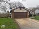 Exterior view of house showing the attached garage, brick facade, and driveway at 10047 Lone Wolf Dr, Indianapolis, IN 46235