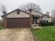 Front exterior view of the house with a two-car garage and well-maintained lawn at 10047 Lone Wolf Dr, Indianapolis, IN 46235