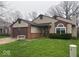 Charming home exterior featuring a two-car garage, well-kept lawn, and welcoming entrance at 10047 Lone Wolf Dr, Indianapolis, IN 46235