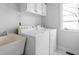 A laundry room featuring a washing machine, dryer, sink, and upper cabinets at 10109 Fergus Ave, Carmel, IN 46032