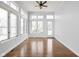 Bright sunroom filled with natural light from large windows, hardwood floors, and a glass door to the outside at 10109 Fergus Ave, Carmel, IN 46032