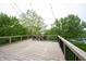 Large wooden deck with black railings and string lights, perfect for outdoor entertaining with wooded views at 10365 Aurora Ct, Fishers, IN 46038