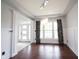 Dining room featuring hardwood floors, wainscoting, large windows, and modern light fixture at 10365 Aurora Ct, Fishers, IN 46038