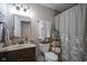 Well-lit bathroom with a decorative shower curtain, floating shelves, and updated vanity at 1127 Island Woods Dr # 56, Indianapolis, IN 46220