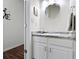 Powder room featuring a white vanity with granite countertop, round mirror and modern fixtures at 11339 Fonthill Dr, Indianapolis, IN 46236