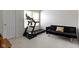 This home gym bedroom has a treadmill, and a black futon couch with 'Happy Summer' throw pillow at 11339 Fonthill Dr, Indianapolis, IN 46236