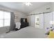 Relaxing bedroom features a TV, a cozy seating area, and sliding barn doors to the bathroom at 11339 Fonthill Dr, Indianapolis, IN 46236