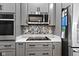 Modern kitchen features stainless steel oven, microwave, and stylish backsplash over quartz countertops at 11339 Fonthill Dr, Indianapolis, IN 46236