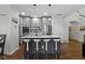 A modern kitchen with a central island, gray cabinets, stainless steel appliances, and four white bar stools at 11339 Fonthill Dr, Indianapolis, IN 46236