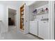 Convenient laundry room with modern washer and dryer, shelving, and adjacent built-in bookcase at 11339 Fonthill Dr, Indianapolis, IN 46236