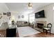 Comfortable living room with a stone fireplace, ceiling fan, and an abundance of natural light at 11339 Fonthill Dr, Indianapolis, IN 46236