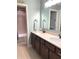 Bathroom featuring a double vanity, large mirror, and tub with tiled surround at 11863 Edgefield Dr, Fishers, IN 46037