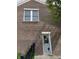 Close up showing the brick exterior with a back door and small square window with plants to the side at 11863 Edgefield Dr, Fishers, IN 46037
