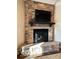Living room featuring a stone fireplace with TV installed above mantle at 11863 Edgefield Dr, Fishers, IN 46037