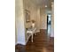 Inviting hallway with hardwood floors, elegant table, and a view into a room with natural light and a neutral palette at 11863 Edgefield Dr, Fishers, IN 46037