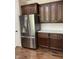 Modern kitchen with stainless steel fridge, white subway tile backsplash, and dark wood cabinets at 11863 Edgefield Dr, Fishers, IN 46037