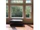 Large windows offer lush green tree views in this room with hardwood floors and a leather window seat at 11863 Edgefield Dr, Fishers, IN 46037