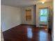 Bright living room featuring hardwood floors, a window with blinds, and an open doorway at 1254 Kenwood Dr, Greenwood, IN 46143