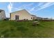 View of a lush backyard with a picnic table, fire pit, and well-maintained grass at 12722 Brady Ln, Noblesville, IN 46060