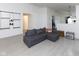 Spacious living room with a gray sofa, light-colored wood floors, and minimalist decor at 12722 Brady Ln, Noblesville, IN 46060