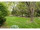 Green backyard with large shade tree and well-maintained lawn offering a tranquil setting at 13778 Driftwood Dr, Carmel, IN 46033