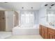 Elegant bathroom featuring a large tub, a separate shower, and a double sink vanity at 13778 Driftwood Dr, Carmel, IN 46033