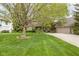 Charming front yard with mature tree, lush lawn, and a welcoming facade with a driveway leading to the garage at 13778 Driftwood Dr, Carmel, IN 46033