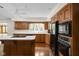Bright kitchen featuring wood cabinets, black appliances, an island cooktop, and ample counter space at 13778 Driftwood Dr, Carmel, IN 46033