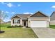 Well-maintained brick home featuring a black front door and two-car garage at 1407 Allen Ct, Shelbyville, IN 46176