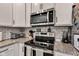 Close-up of stainless steel oven, microwave, and granite countertop in kitchen at 1407 Allen Ct, Shelbyville, IN 46176
