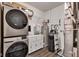 Organized laundry room featuring modern washer and dryer units, ample storage, and updated water heater system at 1407 Allen Ct, Shelbyville, IN 46176