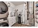 Functional laundry room featuring a stacked washer and dryer, water softener, storage, and updated flooring at 1407 Allen Ct, Shelbyville, IN 46176