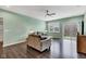 Bright living room showcasing hardwood floors, a ceiling fan, and a glass sliding door to the backyard at 1407 Allen Ct, Shelbyville, IN 46176