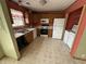 Charming kitchen with wood cabinets, vinyl flooring, and laundry nook featuring washer and dryer at 1424 Ashley Dr, Lebanon, IN 46052